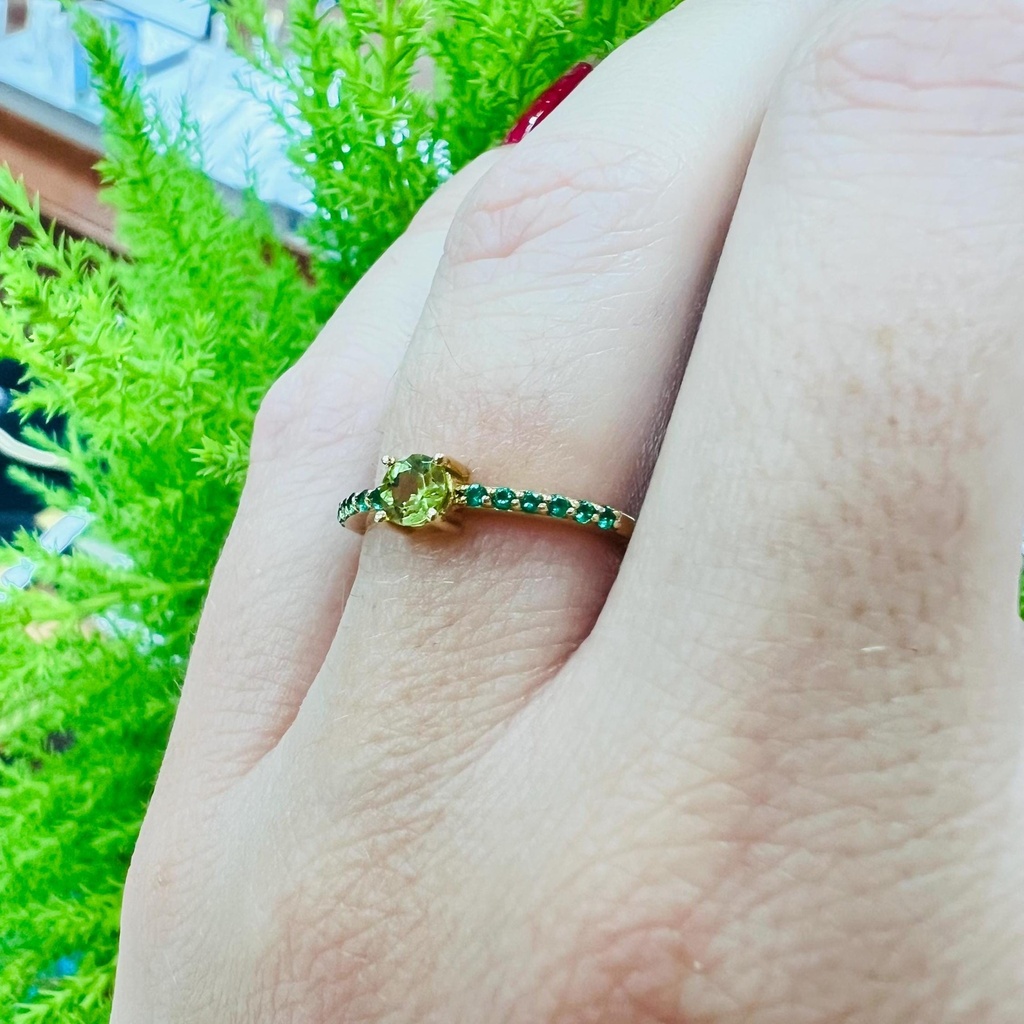 Anillo de oro amarillo de 18 k y Olivina central con pequeños topacios a los lados.